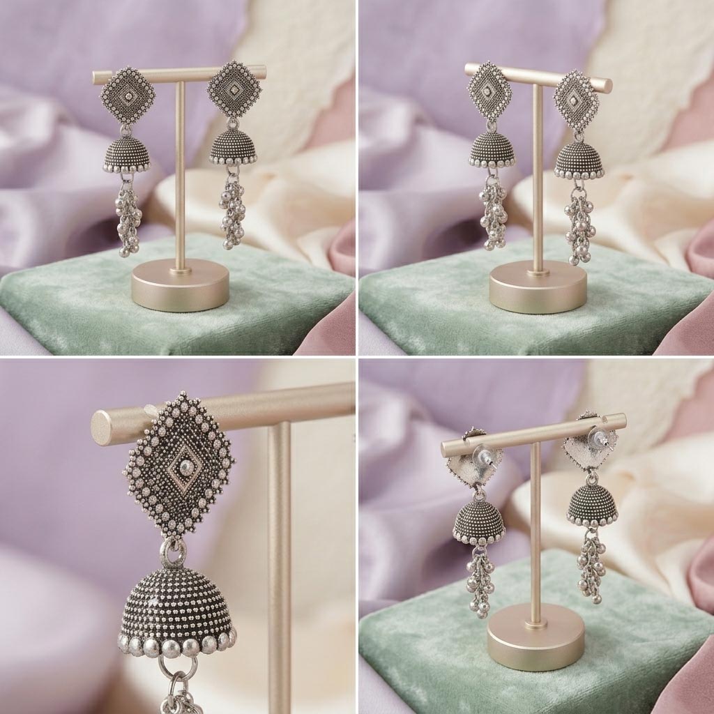 Ornate silver earrings on a stand with a soft pink and green background