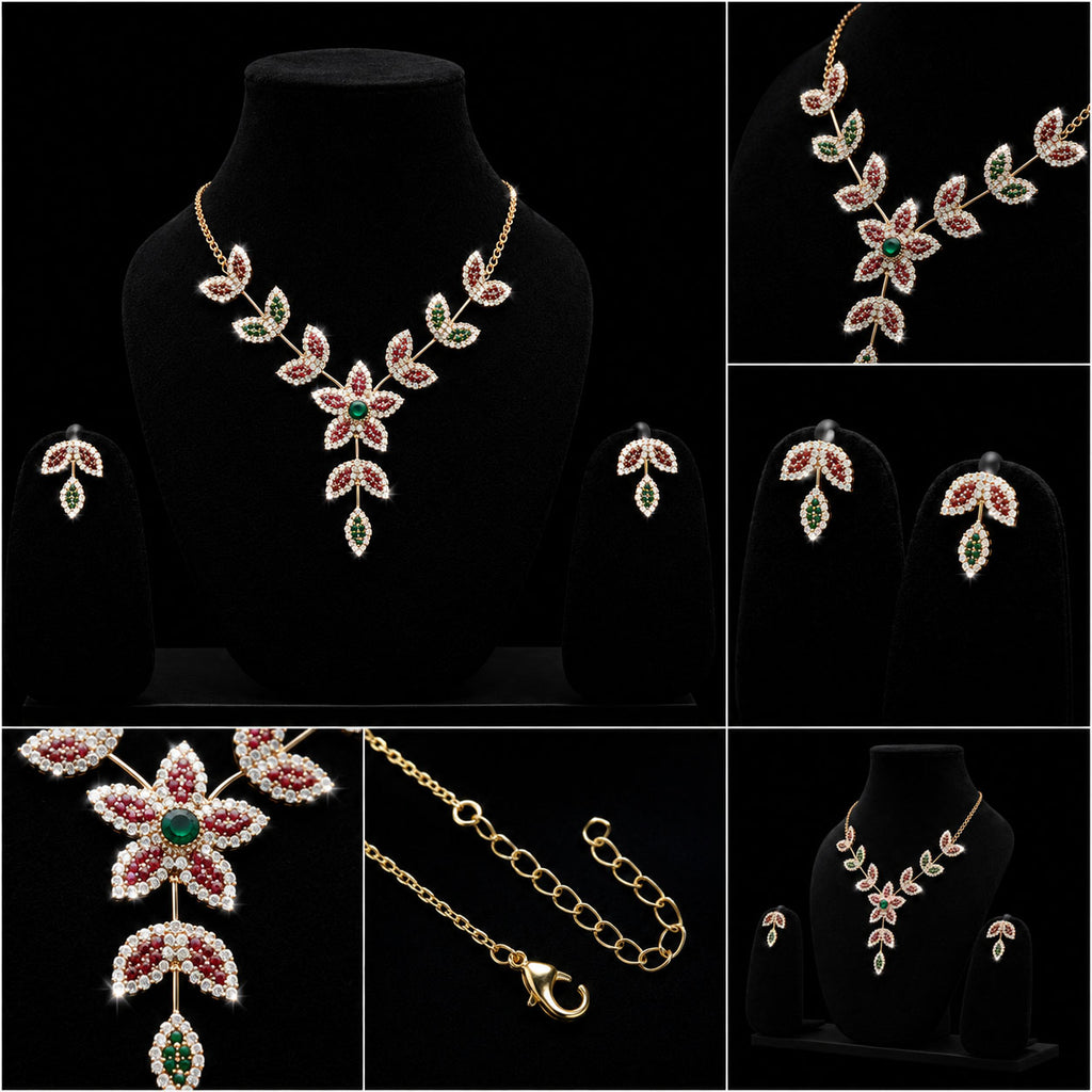Gold floral jewelry set with red and green crystal-like accents, shown on black display busts and close-up detail panels against a black background.
