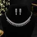 A silver-tone crystal jewelry set including a necklace and matching drop earrings, displayed on a black velvet jewelry bust. The necklace features multiple rows of clear crystals and rectangular clear stones hanging from the bottom.