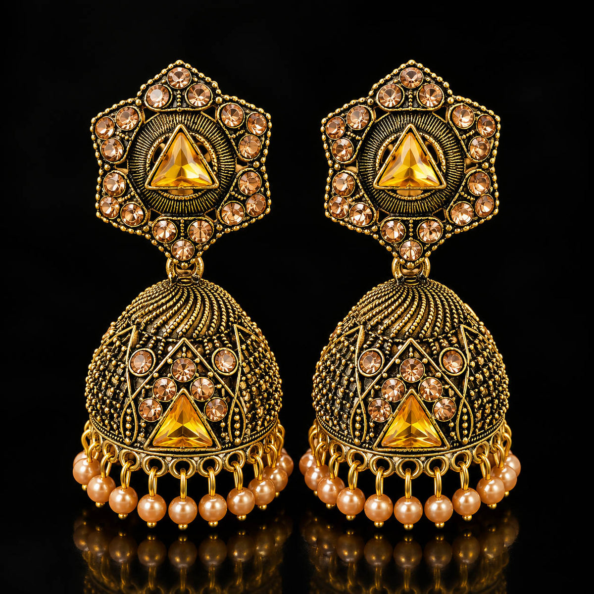 Elevate your ethnic look with these designer antique gold-finish jhumka earrings, featuring intricate detailing, sparkling stones, a statement triangular centerpiece, and delicate pearl-bead drops. Perfect for sarees, lehengas, festive outfits, weddings, and traditional occasions.

Detailed Product Description

Add a touch of royal Indian elegance to your jewellery collection with these beautifully crafted traditional jhumka earrings for women. The earrings feature an ornate antique-gold finish with intrica