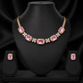 Gold-plated pink gemstone necklace and matching stud earrings displayed on a black jewelry bust against a black satin background.